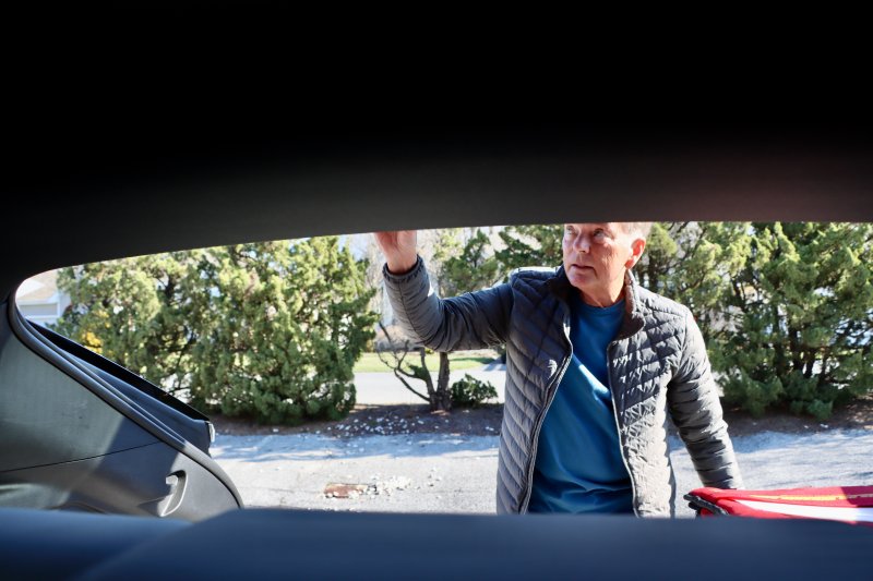 Richard Chambers takes meals from his car during a delivery stop. Chambers knows his clients by name and by heart.